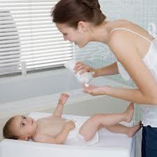 lady putting lotion on baby